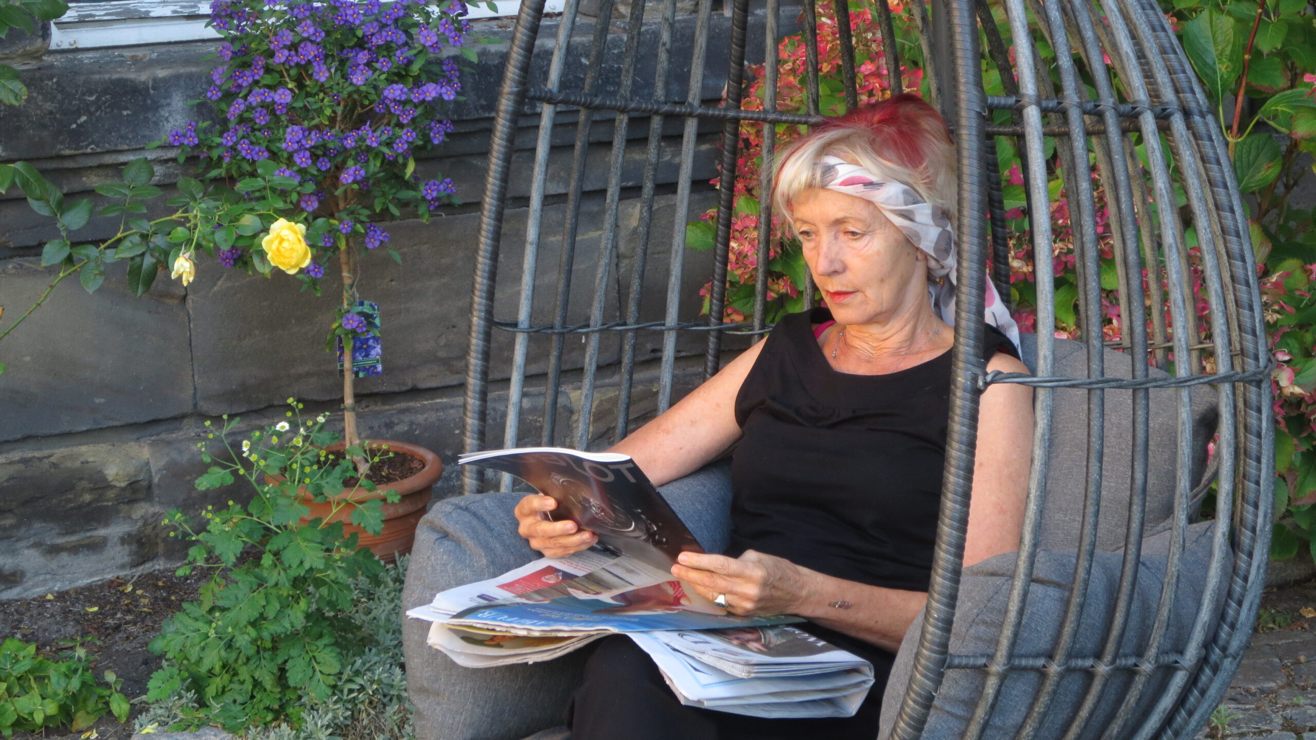 Frau liest entspannt im Garten – Ruhe, Rückzug und innere Balance als Ziel von Hypnose Therapie und psychotherapeutischem Coaching in Bayreuth